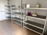 de nombreuses étagères dans la pièce, sur lesquelles sont posés des casseroles et des poêles