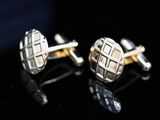 two pairs of silver cufflinks on a black surface