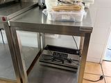 une cuisine avec une table en inox et un grille-pain posé sur le plan de travail