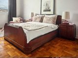 une photo d'une chambre avec du parquet et un grand lit