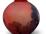 a red and black vase sitting on a white surface