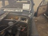 cars are parked in a garage with a lot of junk