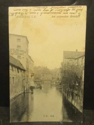 an old photo of a river running through a town