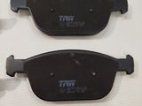 two black brake pads on a white table