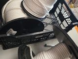 une personne tenant une bobine de corde à côté d'un panier rempli de bobines