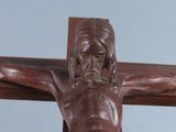 a statue of jesus on the cross with a cross in the background