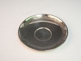 a silver plate on a white table with a green background