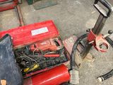 a red machine that is sitting on the ground