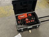 une valise contenant des outils, posée par terre