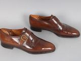 une paire de chaussures en cuir marron avec des boucles sur un fond blanc