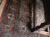 a large rug on the floor next to a wooden bench