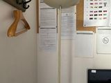 a desk with a computer and a lamp in the corner