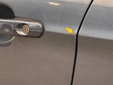 a close up of a car door handle with a yellow arrow pointing to it