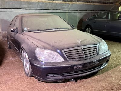 une voiture sale garée dans un garage à côté d'une autre voiture