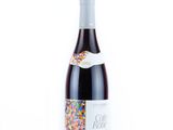 a close up of a bottle of wine on a white surface