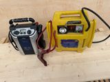 two batteries and a radio sitting on a wooden table
