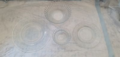 quatre plats en verre sur une table recouverte d'une nappe blanche