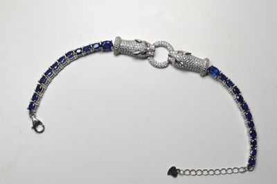 un bracelet en perles bleues et blanches posé sur une table blanche