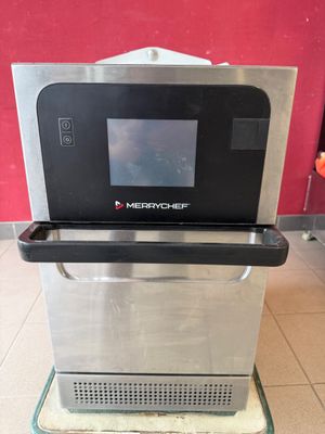 un micro-ondes posé sur une étagère en verre
