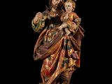 an image of a statue of a man and woman holding a child