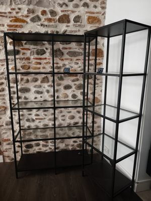un gros plan sur une bibliothèque avec un mur de briques en arrière-plan