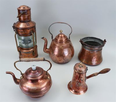 an assortment of antique copper teapots and kettles