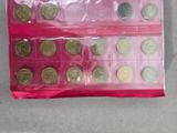 a lot of coins in a pink bag on a table