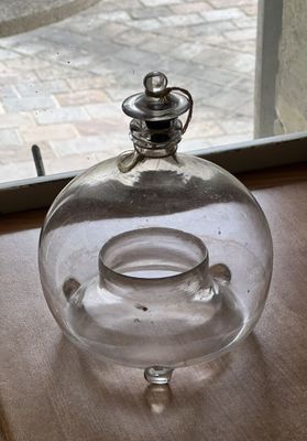 un vase en verre muni d'un couvercle en verre, posé sur une table