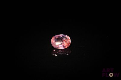 un diamant rose sur une surface noire