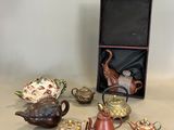 une boîte contenant des théières et d'autres objets, posée sur une table