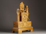 a gold clock that is sitting on top of a stand