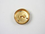 a close up of a gold colored button on a white surface