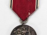 an old medal with a red ribbon and a silver medal on a white background