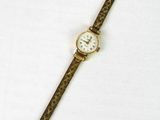 une image d'une montre-bracelet en or avec un cadran blanc
