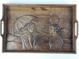 un plateau en bois sur lequel est sculptée la figure d'un homme et d'une femme