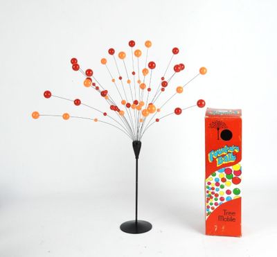 un petit arbre qui se trouve à côté d'une boîte de bonbons