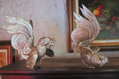 two figurines of birds that are on a table