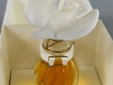 a small bottle of perfume with a flower in it