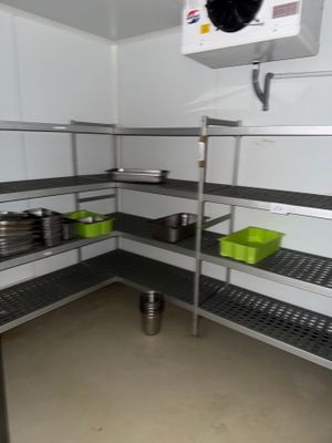 a room with a lot of shelves with pots and pans on them