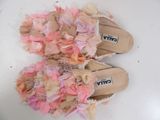 a pair of pink and white slippers on a white surface