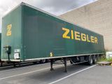 a green semi truck with a yellow ziegler logo parked in a parking lot