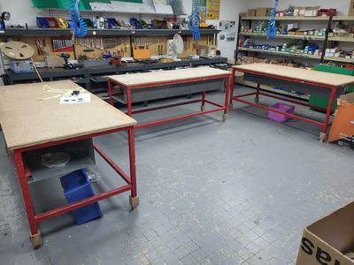 une pièce où se trouvent de nombreux établis et tables de travail