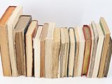 many books stacked on top of each other on a table