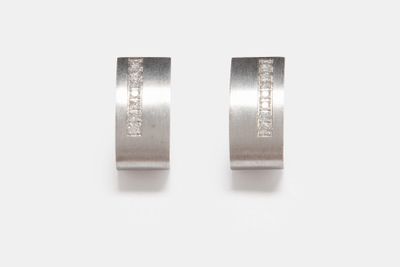 paire de boucles d'oreilles en or blanc et diamants sur fond blanc