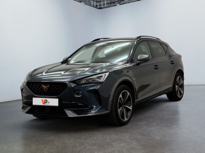 Une voiture grise est garée dans une grande pièce.