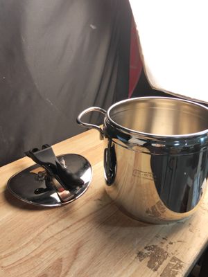 une grande casserole posée sur une table en bois, à côté d'un couteau