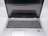 a silver laptop with a black keyboard on a white surface
