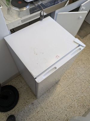 a white refrigerator sitting in a kitchen next to a stove