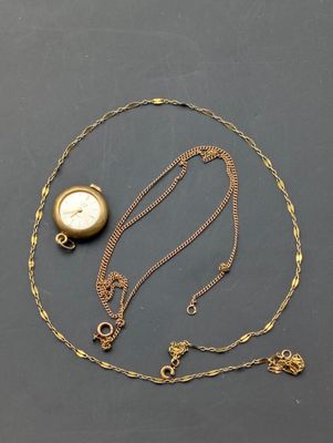 a close up of a gold necklace with a clock on it