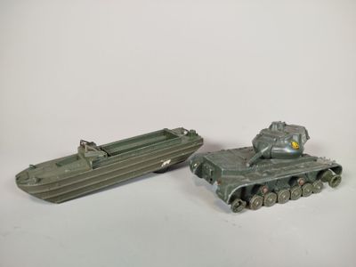 deux véhicules militaires miniatures et un bateau posés sur une surface blanche